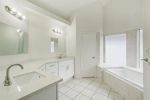 a spacious bathroom with a bathtub sink and mirror