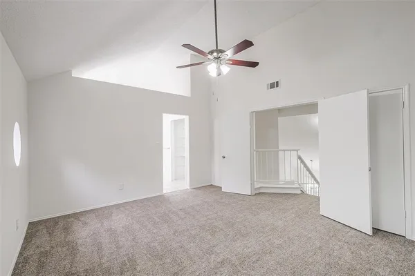 a view of an empty room with a ceiling fan