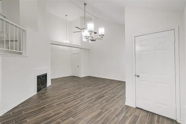 a view of empty room with wooden floor and ceiling fan