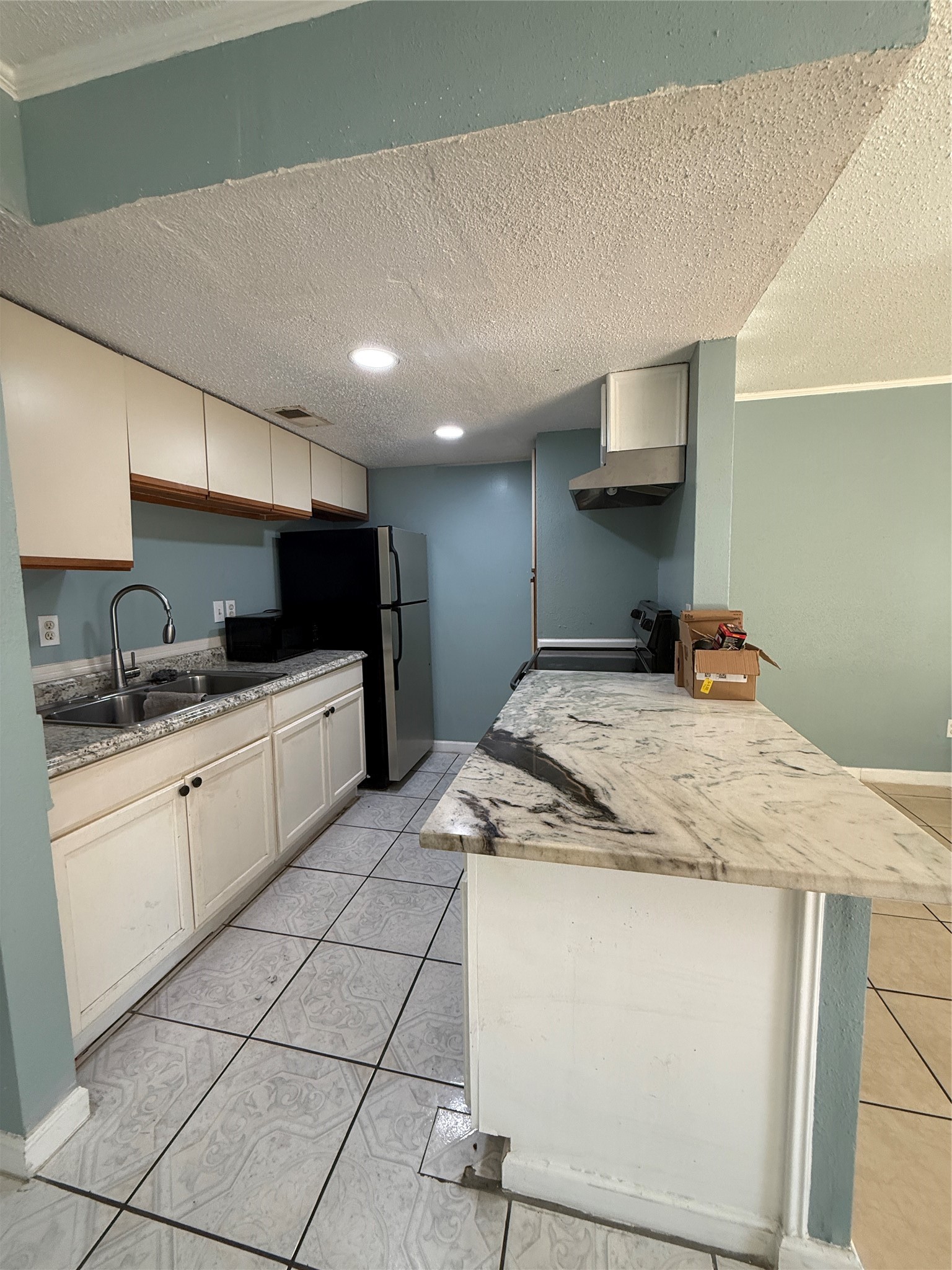 7402 Alabonson Road, Unit 407 Houston, TX 77088 - Photo 5 of 14 a kitchen with stainless steel appliances kitchen island granite countertop a sink and cabinets