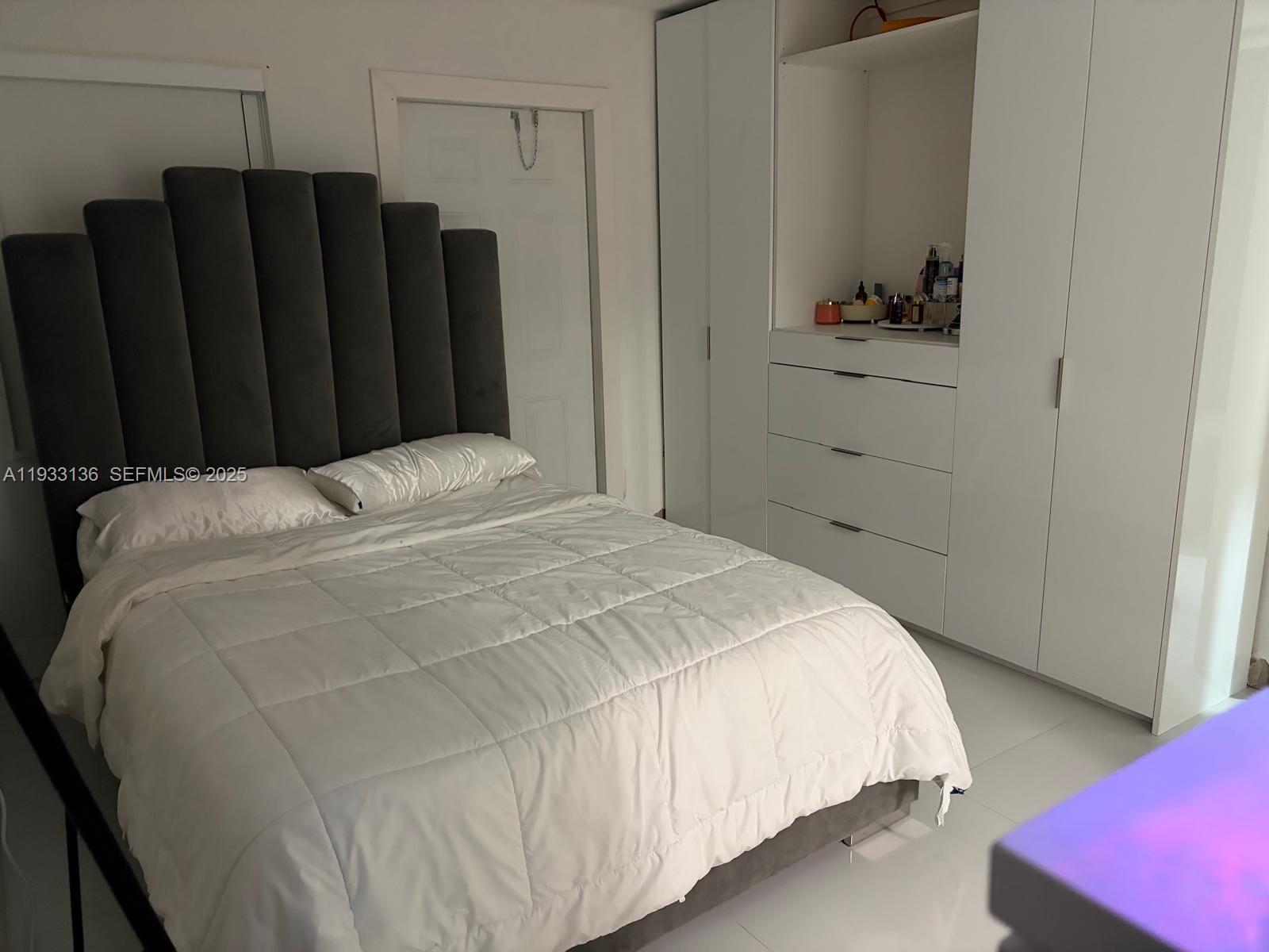 5168 East 8th Lane Hialeah, FL 33013 - Photo 11 of 19 a bedroom with a bed and wooden floor