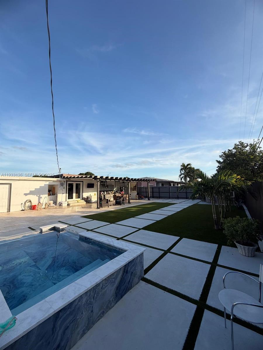 5168 East 8th Lane Hialeah, FL 33013 - Photo 14 of 19 a view of a swimming pool with a yard