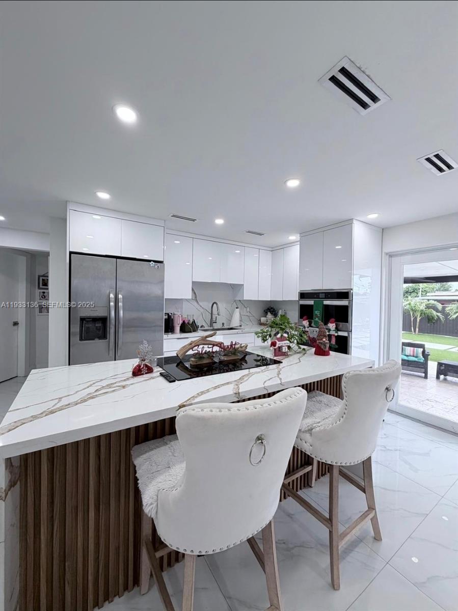 5168 East 8th Lane Hialeah, FL 33013 - Photo 2 of 19 a large kitchen with a table and chairs