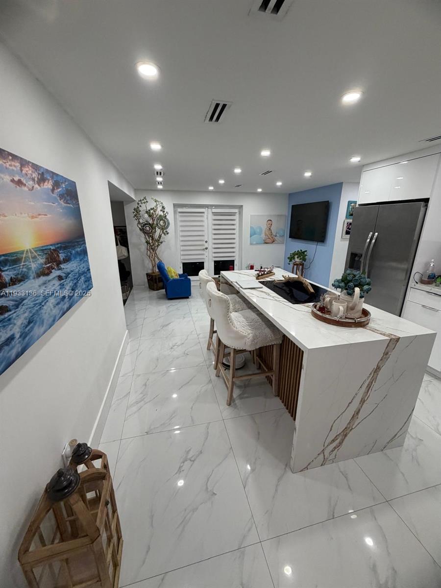 5168 East 8th Lane Hialeah, FL 33013 - Photo 3 of 19 a room with furniture and a flat screen tv