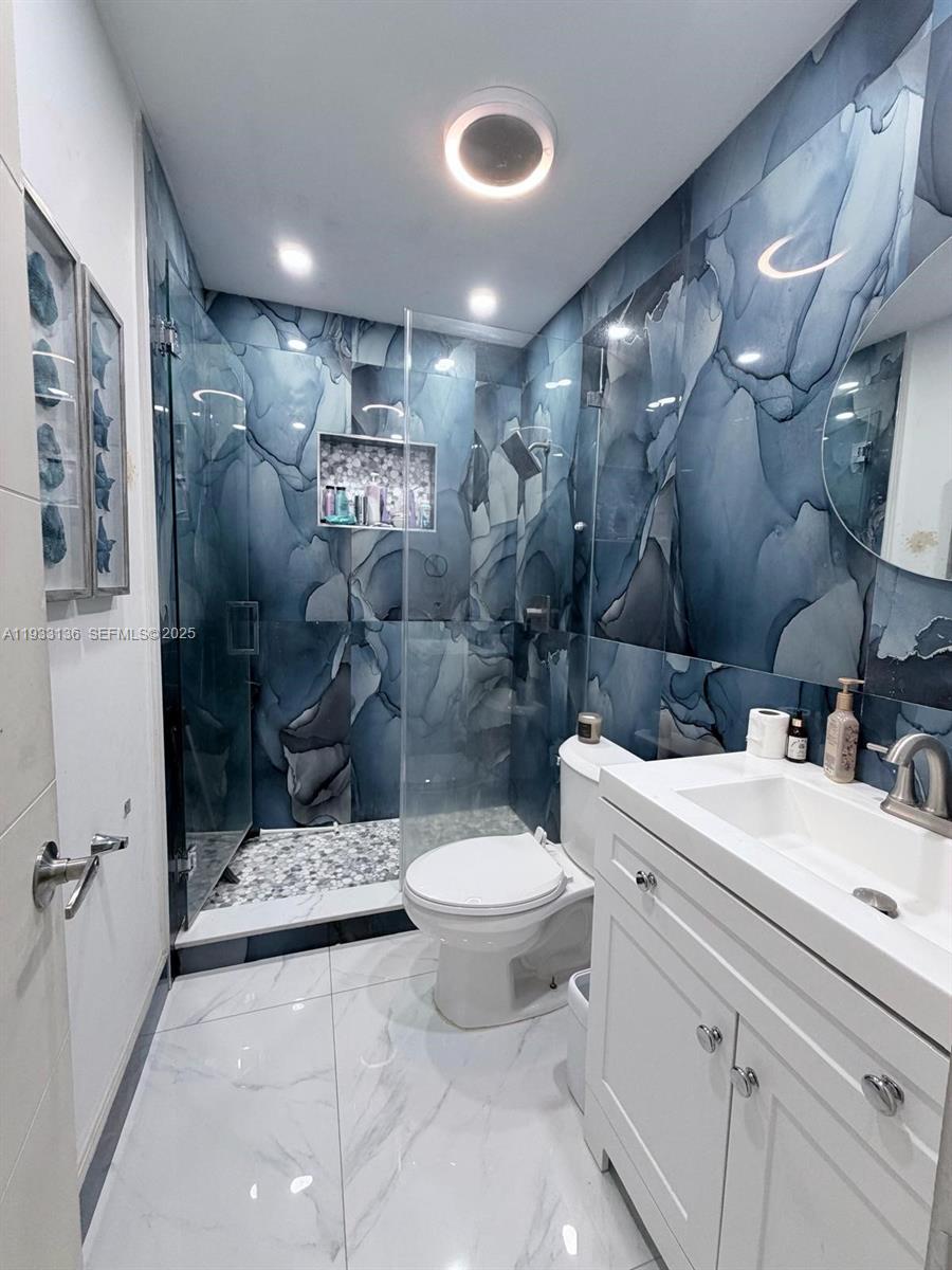 5168 East 8th Lane Hialeah, FL 33013 - Photo 7 of 19 a bathroom with a sink toilet and shower