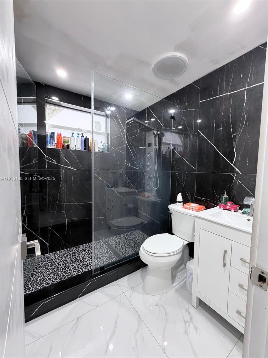 5168 East 8th Lane Hialeah, FL 33013 - Photo 8 of 19 a bathroom with a shower toilet and a sink