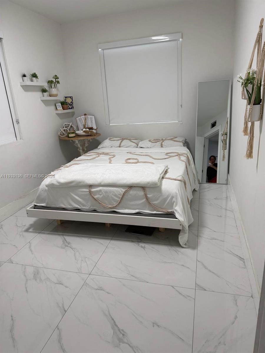 5168 East 8th Lane Hialeah, FL 33013 - Photo 10 of 19 a bedroom with a bed and a cabinets