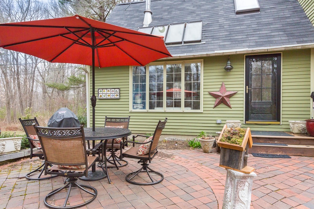7 Buttonwood Road Amesbury, MA 01913 - Photo 2 of 29 a view of a patio with a table and chairs under an umbrella