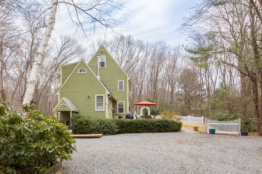 7 Buttonwood Road Amesbury, MA 01913 - Photo 27 of 29 a front view of a house with a garden and trees