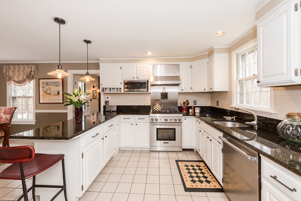 7 Buttonwood Road Amesbury, MA 01913 - Photo 5 of 29 a kitchen with stainless steel appliances kitchen island granite countertop a sink a stove a refrigerator cabinets and chairs