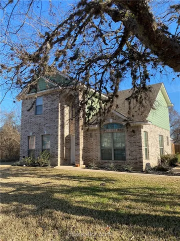 a view of a house with a large tree