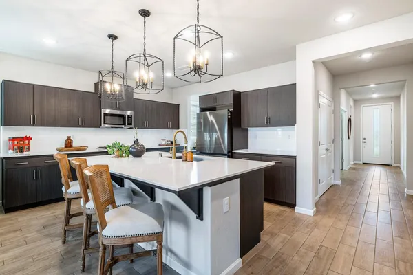 a kitchen with a dining table chairs and stainless steel appliances