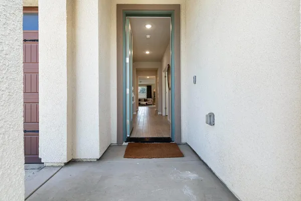 a view of a hallway with wooden floor and a livingroom with a bathroom