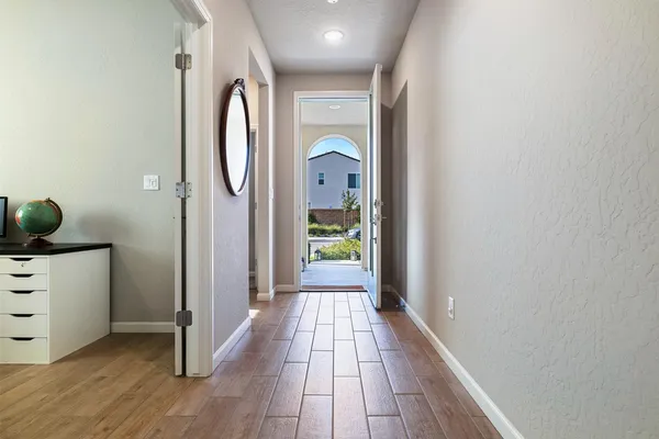 a view of a hallway with wooden floor and closet