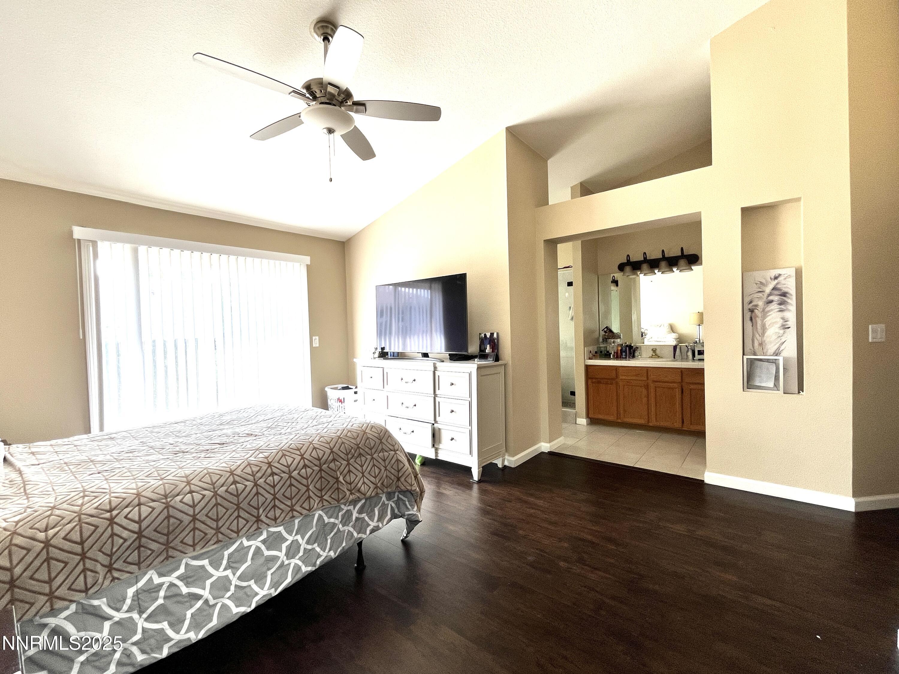 5870 Blue Horizon Drive Reno, NV 89523 - Photo 12 of 21 a bedroom with a large bed a flat tv screen and a ceiling fan