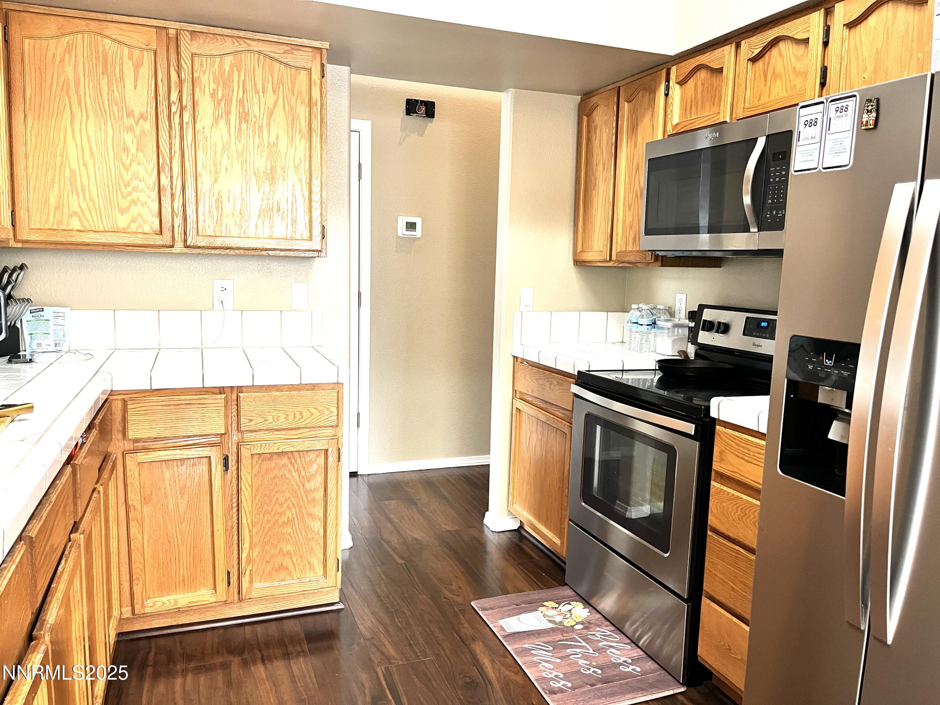 5870 Blue Horizon Drive Reno, NV 89523 - Photo 8 of 21 a kitchen with stainless steel appliances granite countertop a stove a sink and a microwave