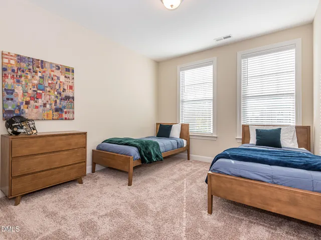 a bed sitting in a bedroom next to a window