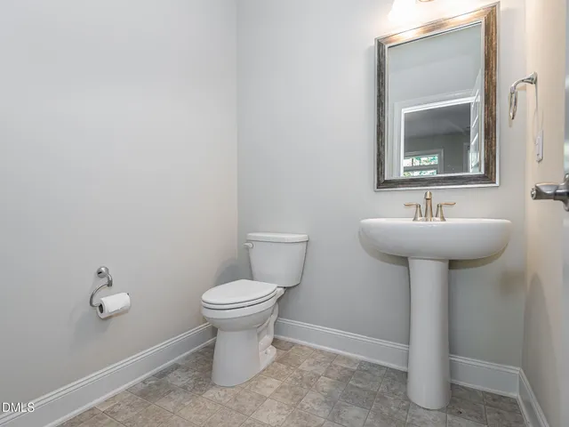 a bathroom with a sink mirror and toilet