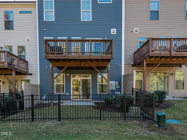 a view of a brick house with many windows and plants