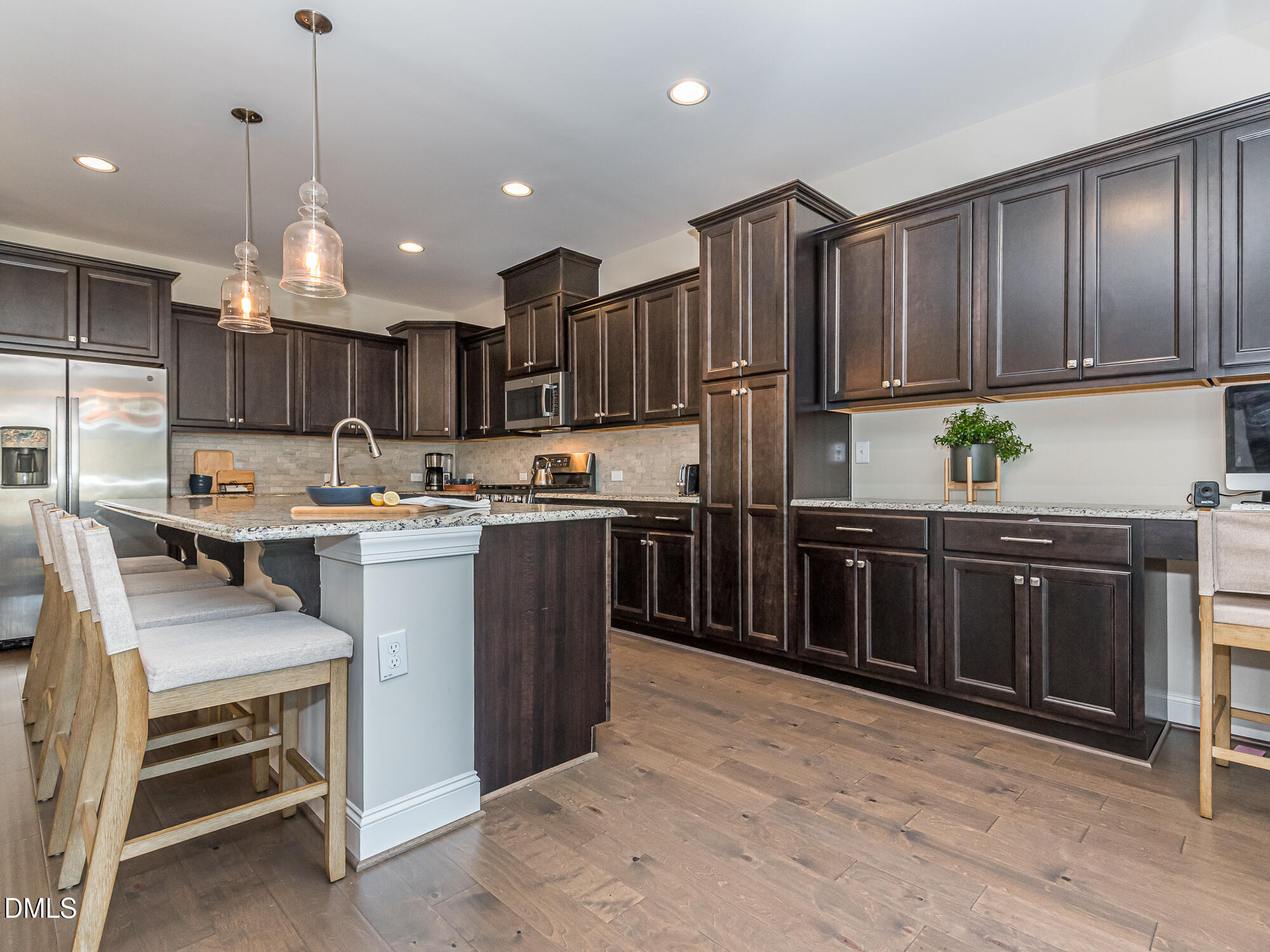 904 Dalton Ridge Place Apex, NC 27523 - Photo 2 of 36 a kitchen with kitchen island granite countertop wooden cabinets and stainless steel appliances