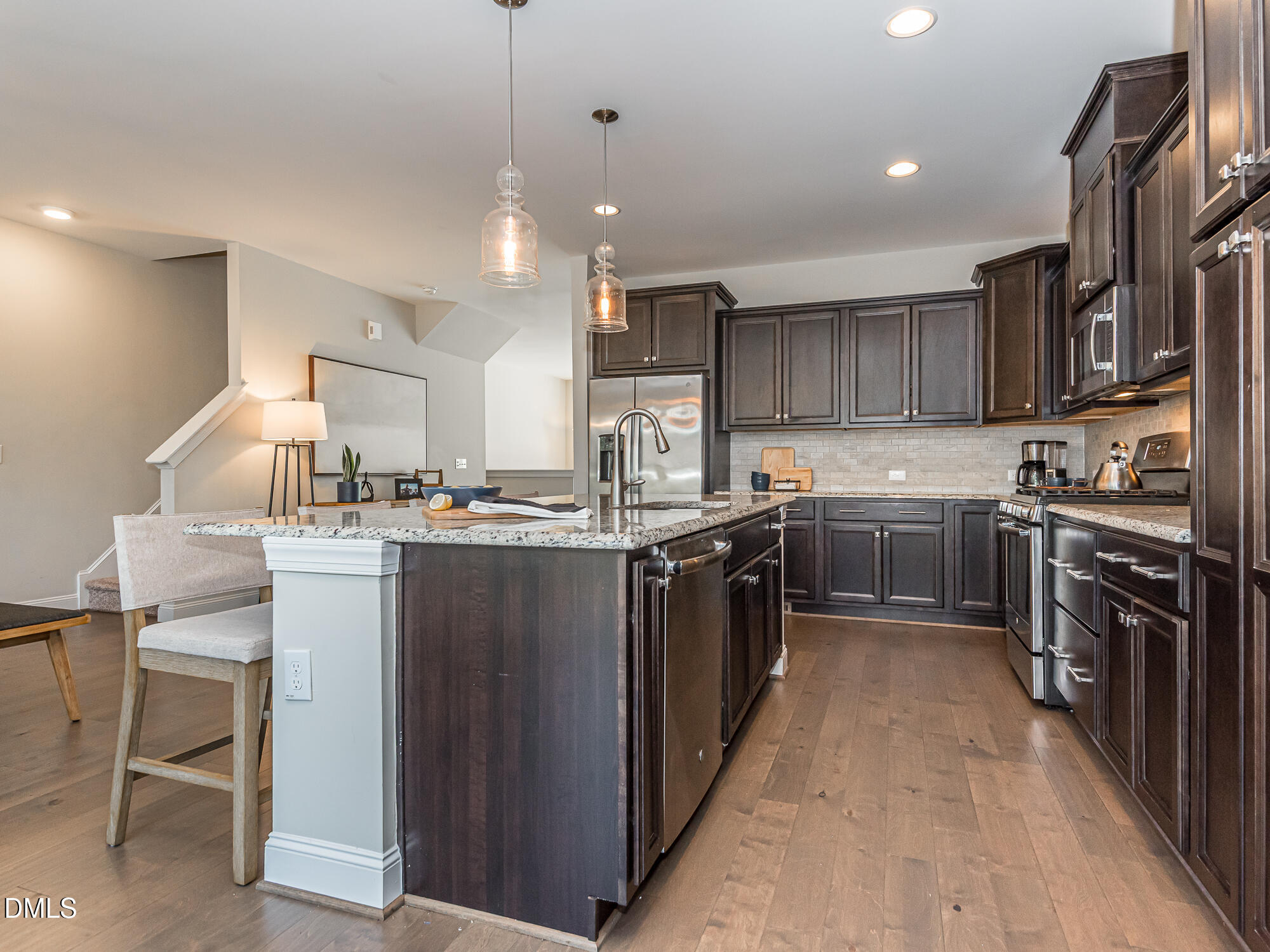 904 Dalton Ridge Place Apex, NC 27523 - Photo 4 of 36 a kitchen with kitchen island granite countertop wooden cabinets stainless steel appliances and a center island
