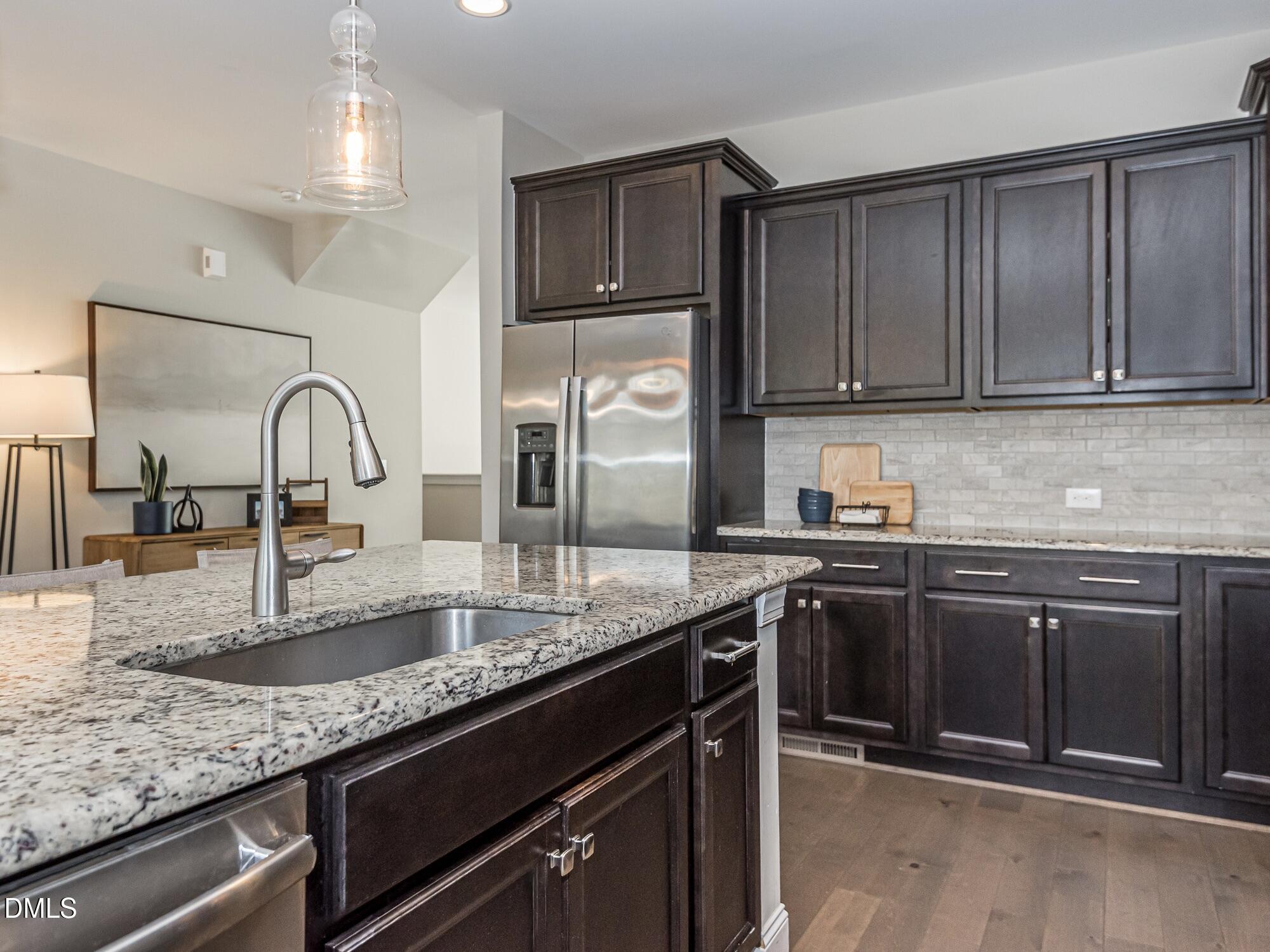 904 Dalton Ridge Place Apex, NC 27523 - Photo 5 of 36 a kitchen with granite countertop cabinets a sink and stainless steel appliances