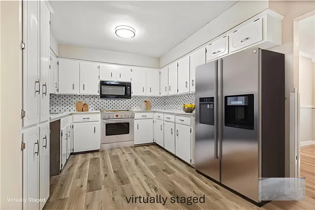 a kitchen with stainless steel appliances cabinets a microwave a sink and a refrigerator