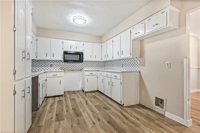 a kitchen with granite countertop white cabinets and white appliances