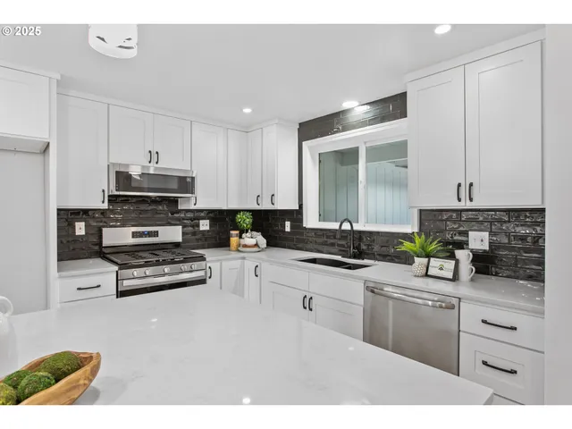 a kitchen with appliances a sink and cabinets