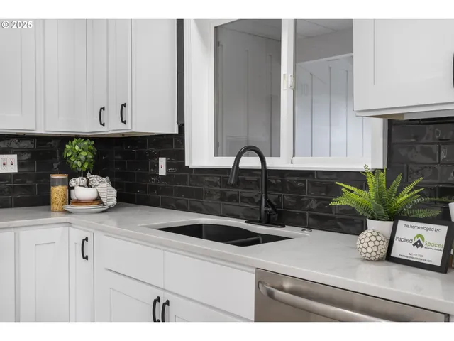 a kitchen with a sink a potted plant and cabinets