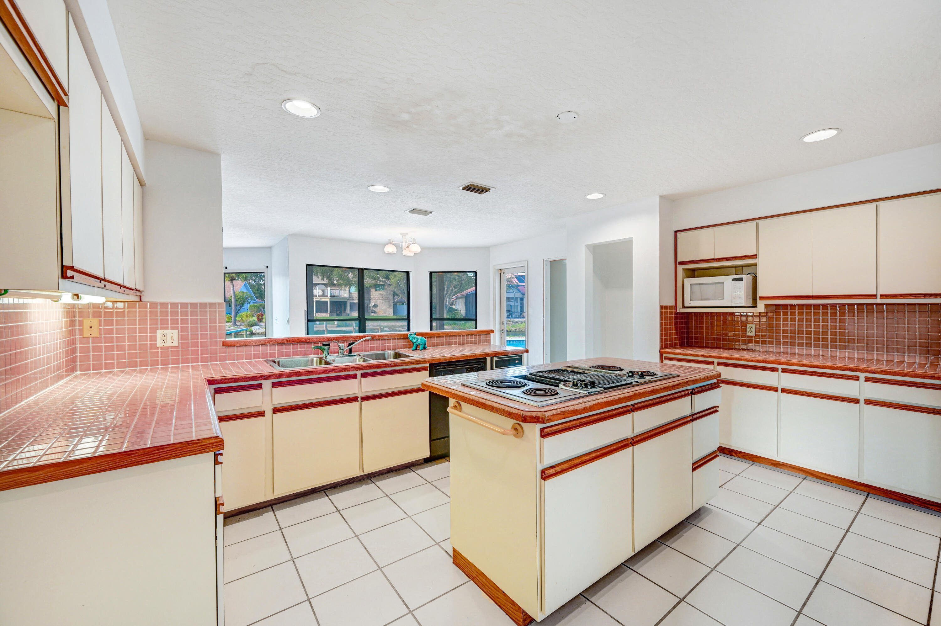 3 Inwood Way Indian Harbour Beach, FL 32937 - Photo 9 of 35 a kitchen with stainless steel appliances a stove and white cabinets