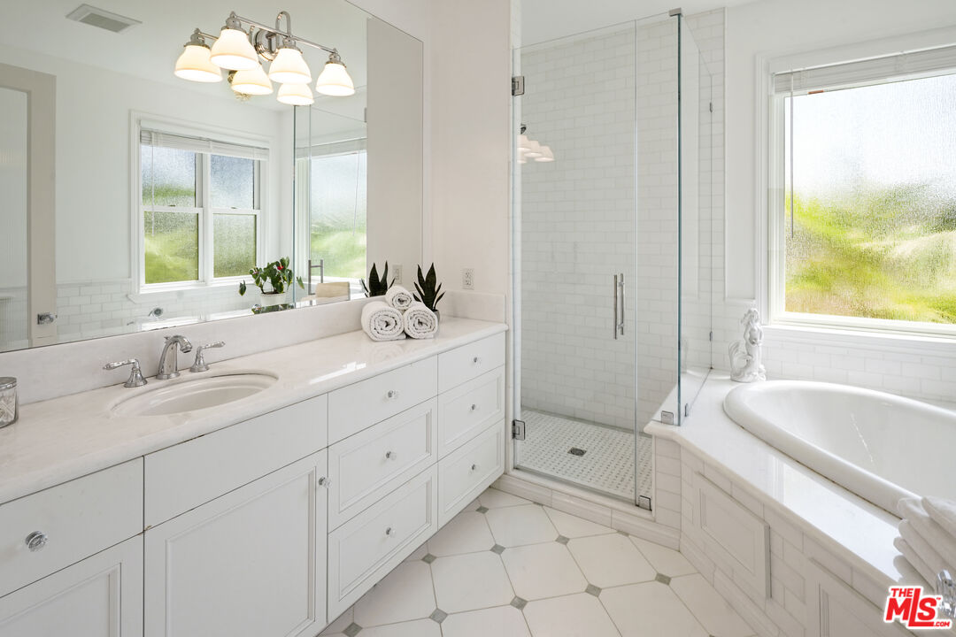 6544 Wandermere Road Malibu, CA 90265 - Photo 16 of 36 a spacious bathroom with double sink a mirror a window and a bathtub