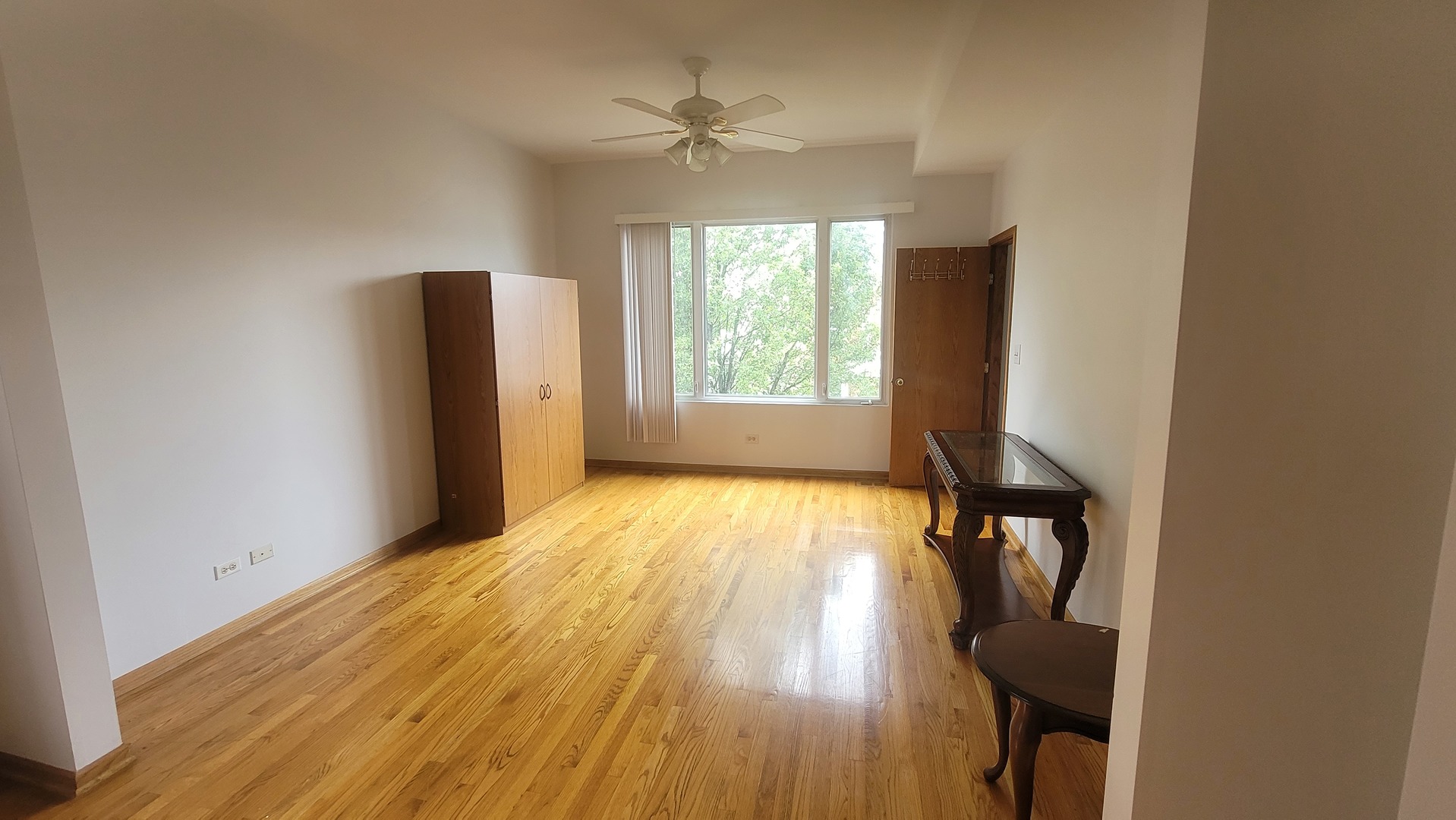 2977 North Lawndale Avenue, Unit 2 Chicago, IL 60618 - Photo 2 of 15 an empty room with wooden floor and windows