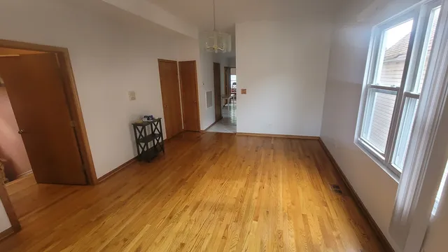 a view of a room with wooden floor and window