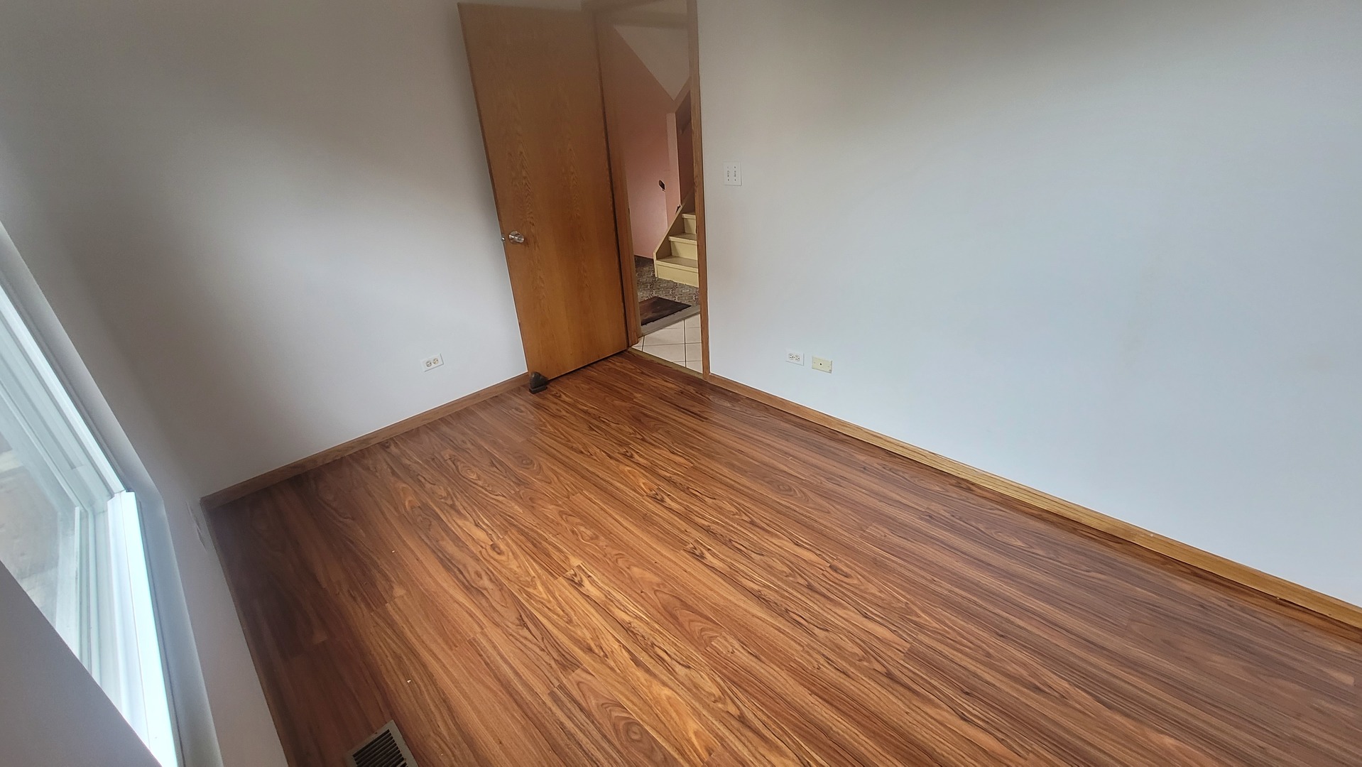 2977 North Lawndale Avenue, Unit 2 Chicago, IL 60618 - Photo 5 of 15 an empty room with wooden floor and windows