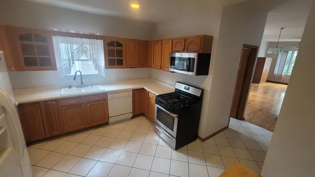 a kitchen with stainless steel appliances granite countertop a refrigerator and a sink