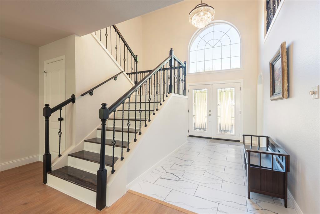 2020 Arbor Bend Road Bonham, TX 75418 - Photo 6 of 40 Entrance foyer with New staircase, french doors, light marble finish flooring, a high ceiling, and hanging lights