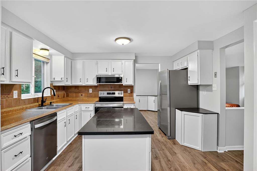 1240 Manor Drive Upper St. Clair, PA 15241 - Photo 6 of 24 a kitchen with a refrigerator a sink a stove a microwave and wooden cabinets