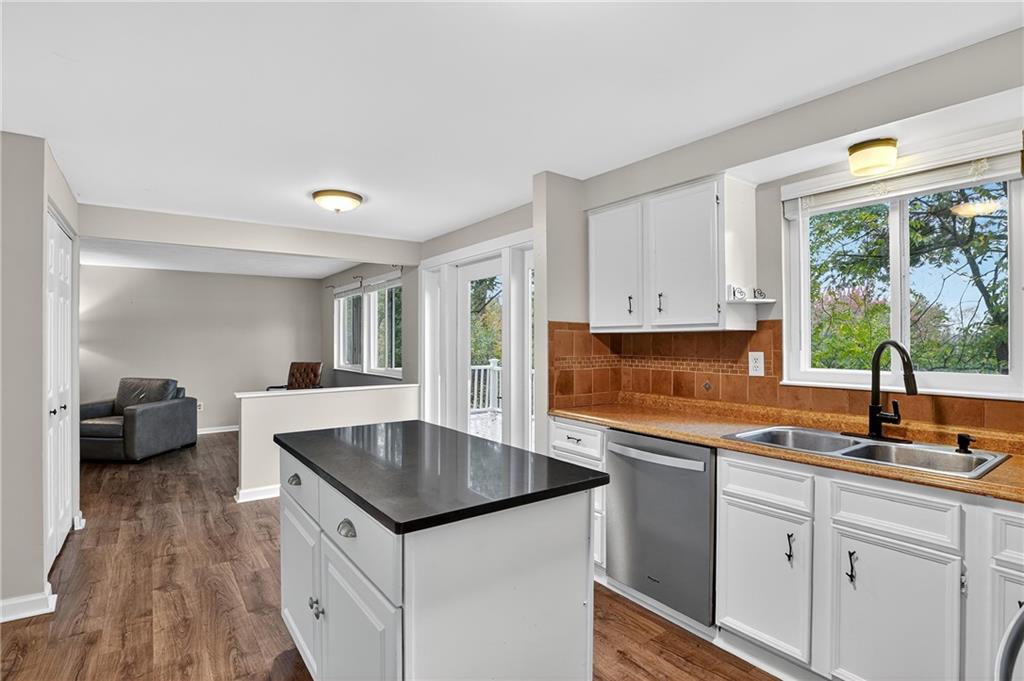 1240 Manor Drive Upper St. Clair, PA 15241 - Photo 8 of 24 a kitchen with granite countertop a sink and a stove top oven with wooden floor