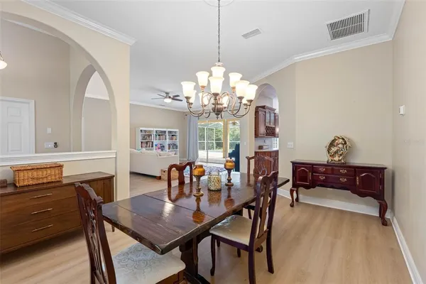 a dining room with furniture a chandelier and wooden floor