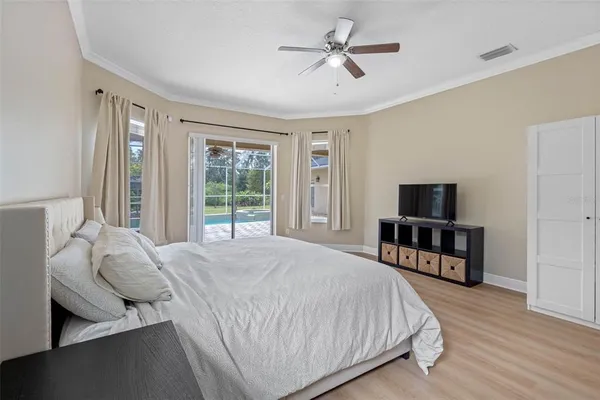 a spacious bedroom with a bed a dresser and a flat screen tv