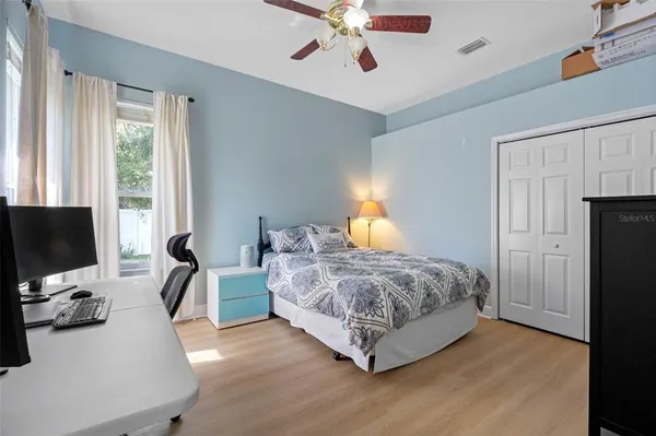 a bedroom with bed a flat tv screen and a dresser