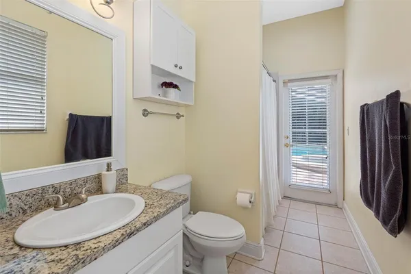 a bathroom with a granite countertop toilet sink and mirror