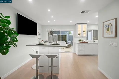 a large kitchen with granite countertop a large counter top a sink and stainless steel appliances