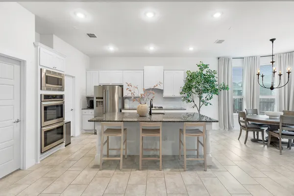 a kitchen with stainless steel appliances kitchen island granite countertop a refrigerator and a stove top oven