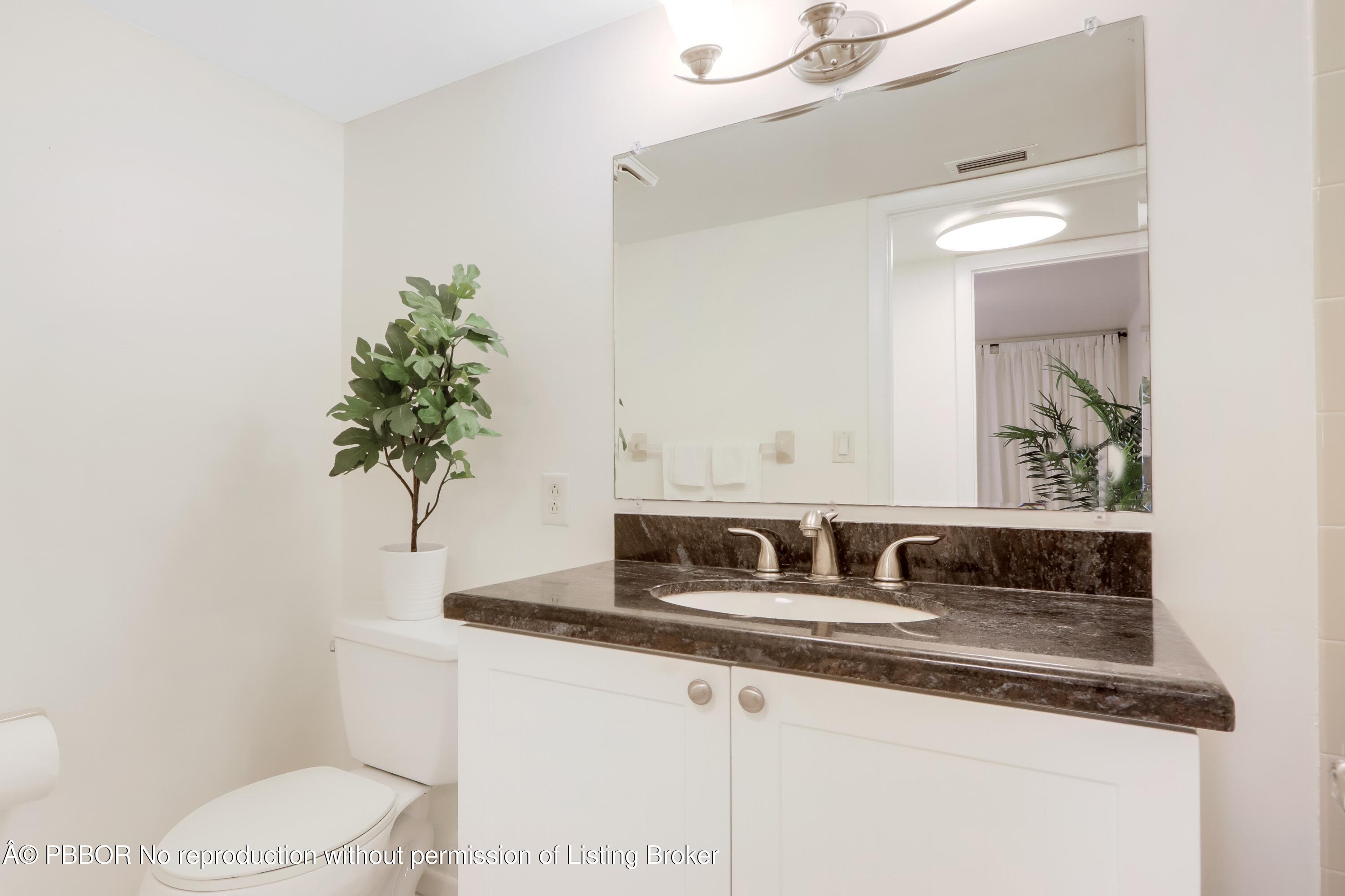 3525 South Ocean Boulevard, Unit 108 Palm Beach, FL 33480 - Photo 13 of 13 a bathroom with a toilet sink and mirror