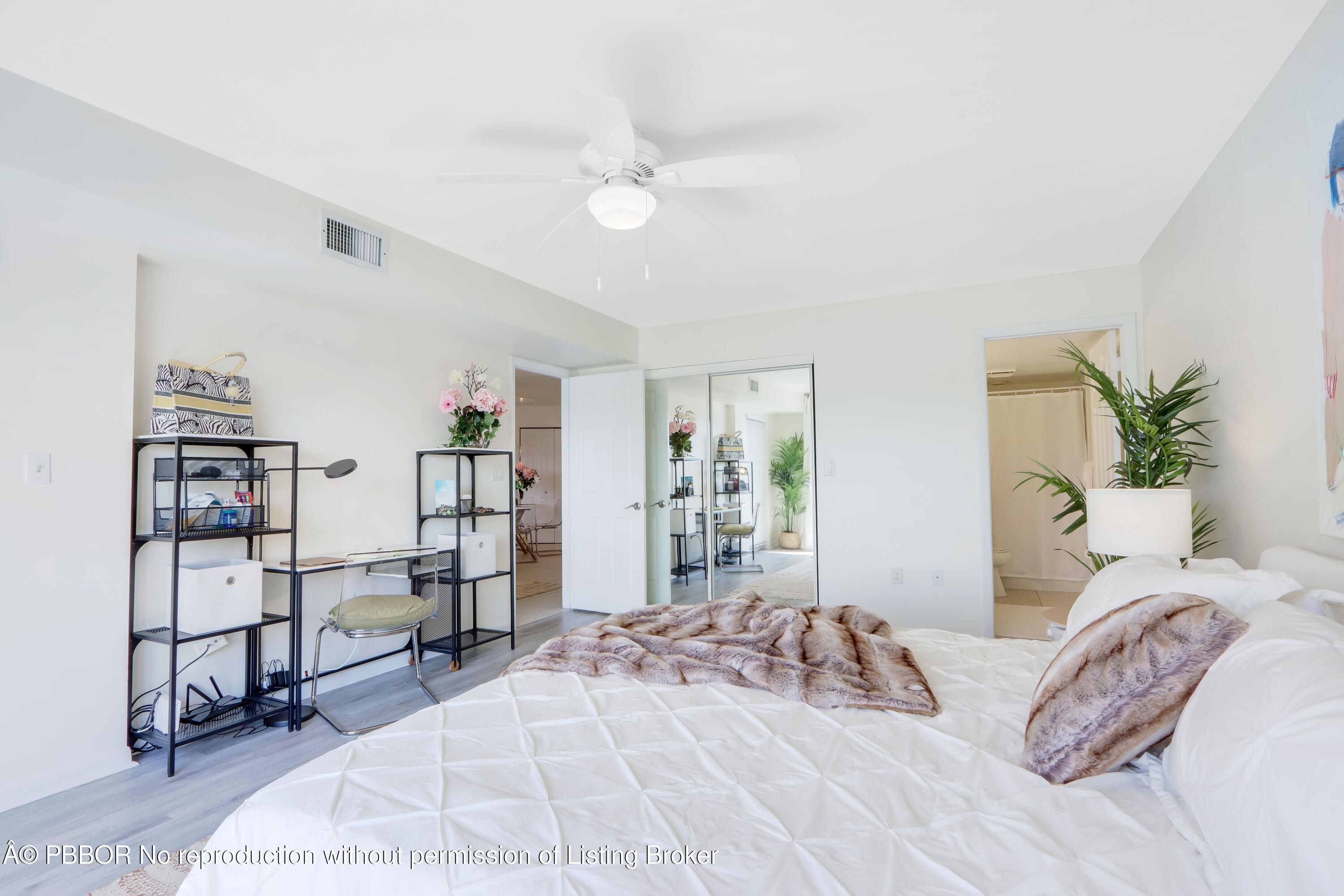 3525 South Ocean Boulevard, Unit 108 Palm Beach, FL 33480 - Photo 9 of 13 a bedroom with a large bed and a chandelier