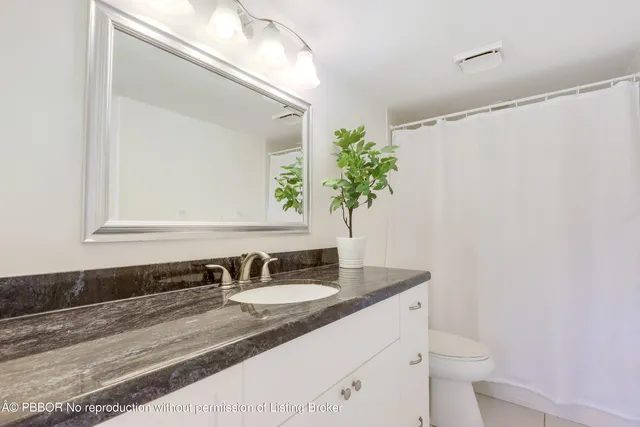 a bathroom with a granite countertop sink and a mirror