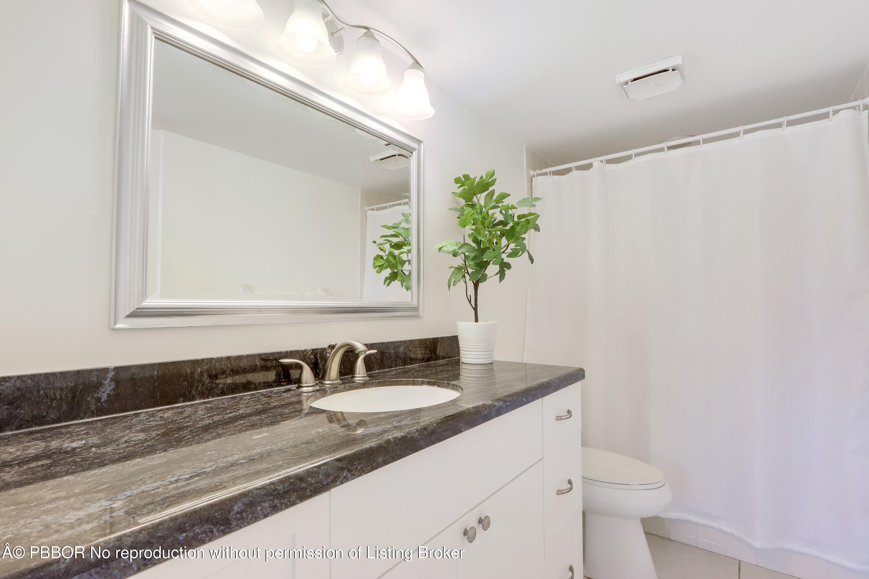 3525 South Ocean Boulevard, Unit 108 Palm Beach, FL 33480 - Photo 10 of 13 a bathroom with a granite countertop sink and a mirror