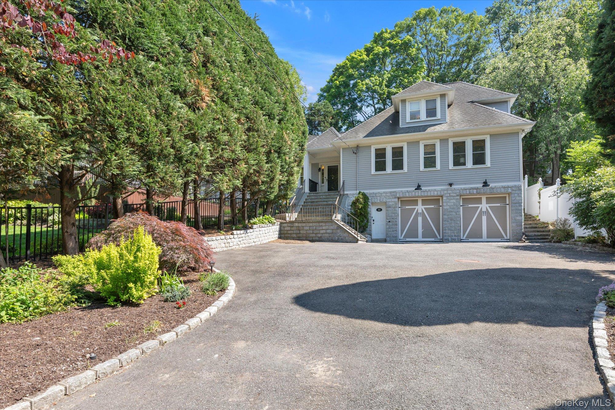 80 Skunks Misery Road Locust Valley, NY 11560 - Photo 4 of 25 a front view of a house with a yard and a garage